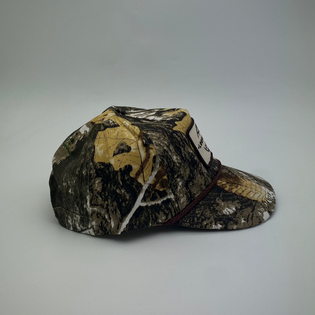 LOOPER Patch Cap V1 Bushland Camo lifestyle shot — unique camo pattern, snap strap, semi-curved brim